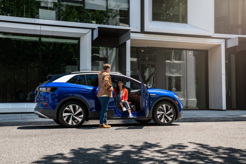 A man and woman getting out of a Volkswagen ID.4
