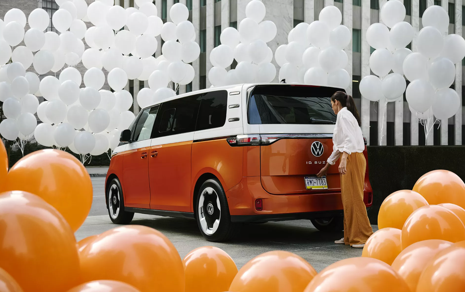 vintage orange Volkswagen surrounded by orange and white balloons